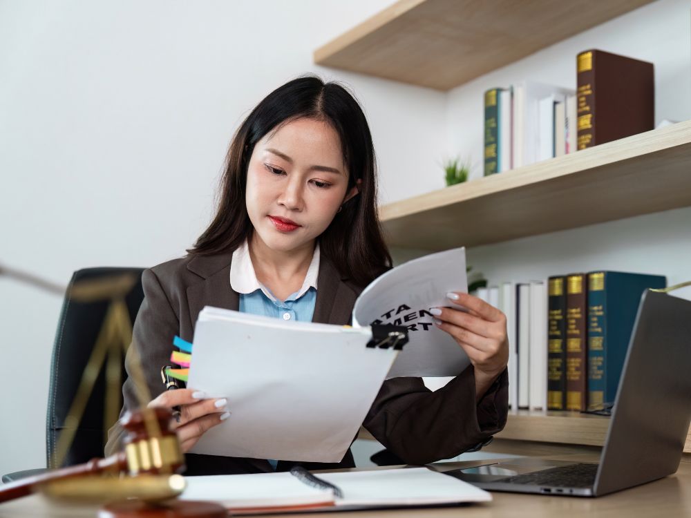 Profissional analisando documentos em escritório com livros jurídicos ao fundo, representando processo e orientações sobre como tirar o CRECI jurídico SP.